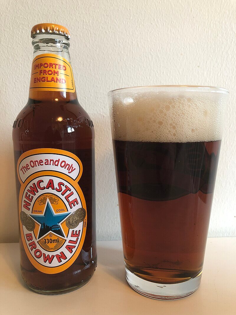 newcastle brown ale poured in pint glass